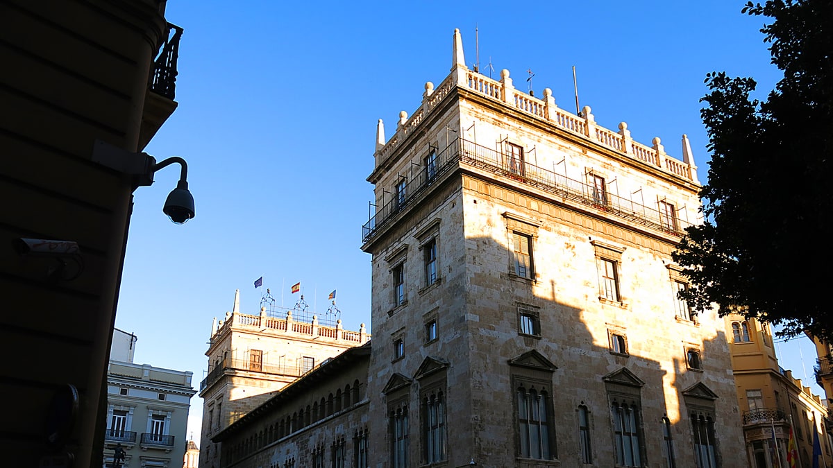 Torre y fachada del Palau de la Generalitat en la plaza de Manises al atardecer.
