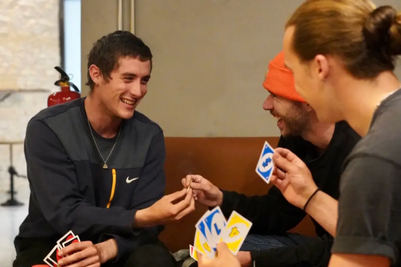Jóvenes jugando a las cartas en un club de cannabis.