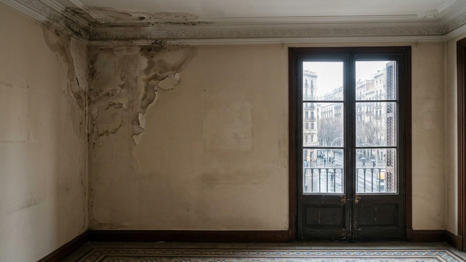 Mancha de humedad por filtración en la pared de un piso antiguo de Barcelona tras las lluvias de otoño